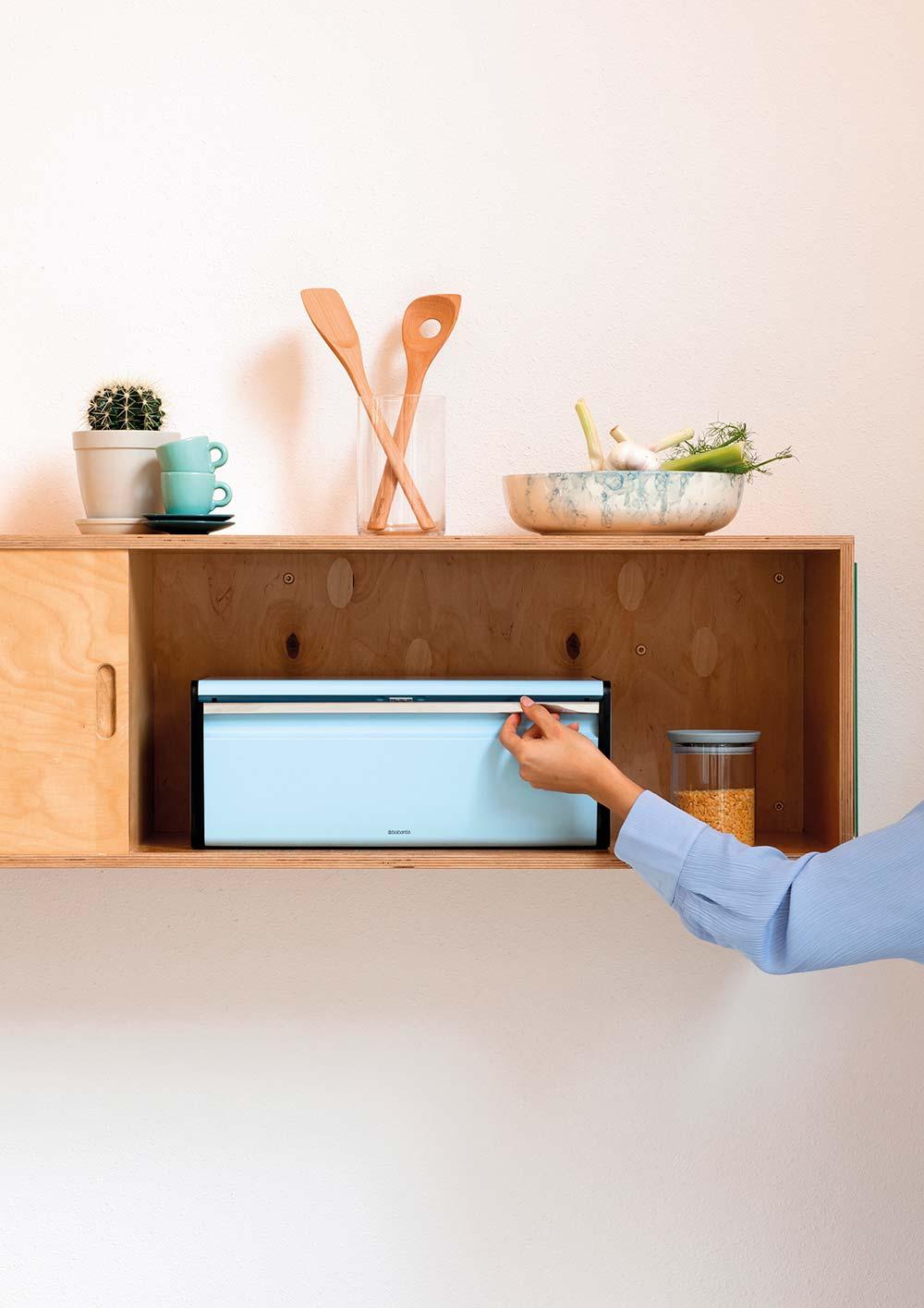 Brandle - Moodfotografie voor Brabantia Minimalistische houten wandkast in een keuken met een geïntegreerde Brabantia broodtrommel en decoratieve accessoires.